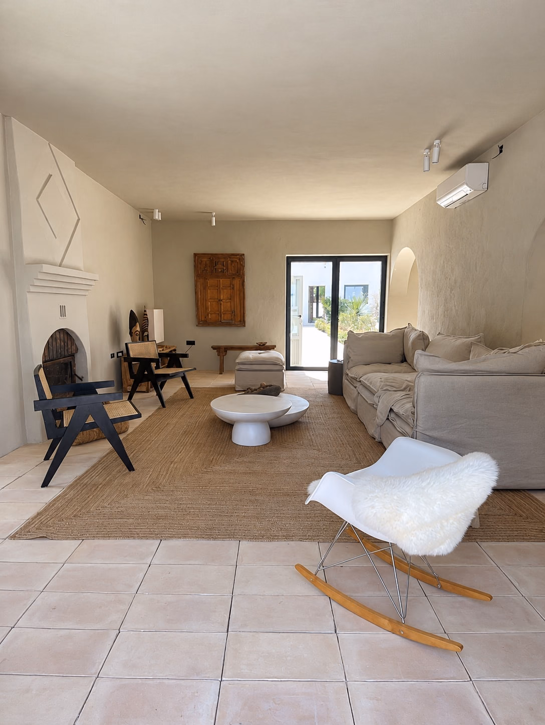 Salon avec cheminée, long canapé et fauteuil à bascule